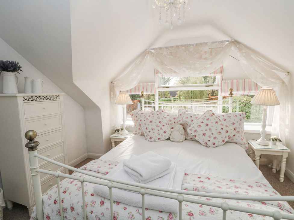 A bedroom with a bed and dressers at Curlew Cottage, Lower Peover, Cheshire