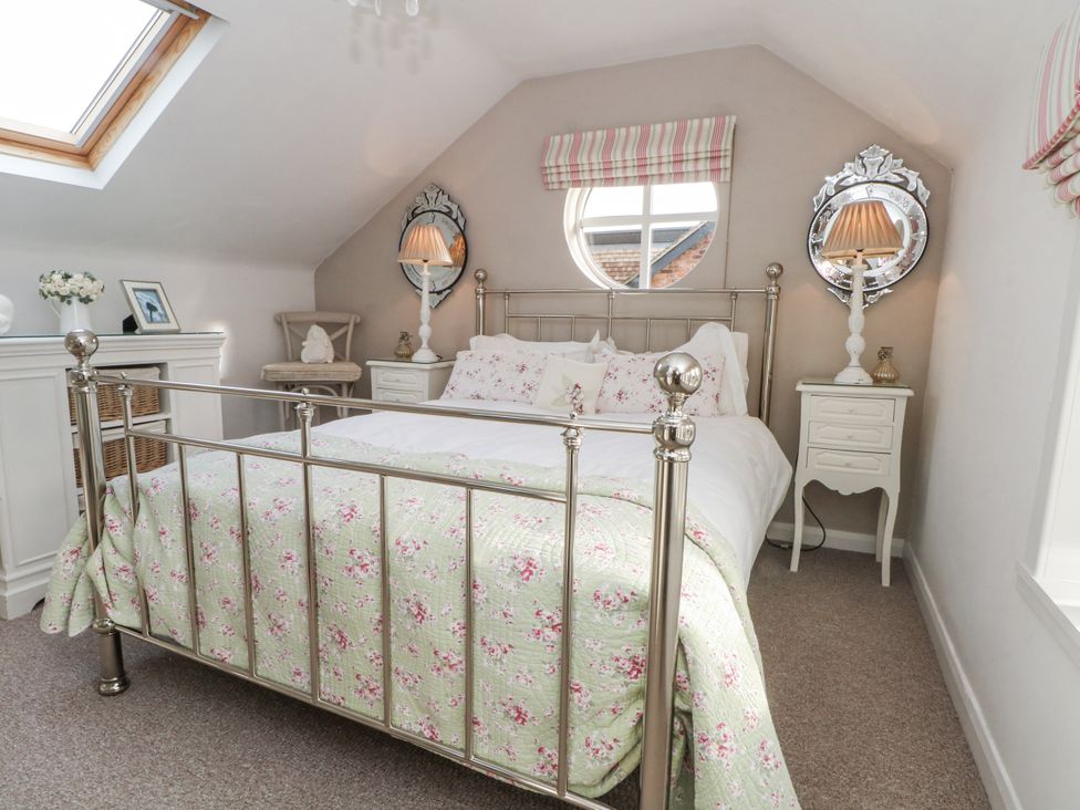 A bedroom with a bed and bedside table at Curlew Cottage in Lower Peover, Cheshire