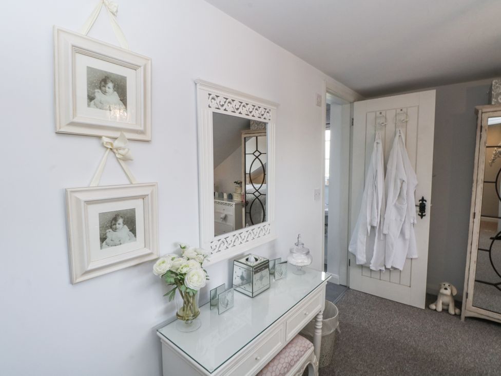 A dressing room with a mirror and vanity table at Curlew Cottage in Lower Peover, Cheshire