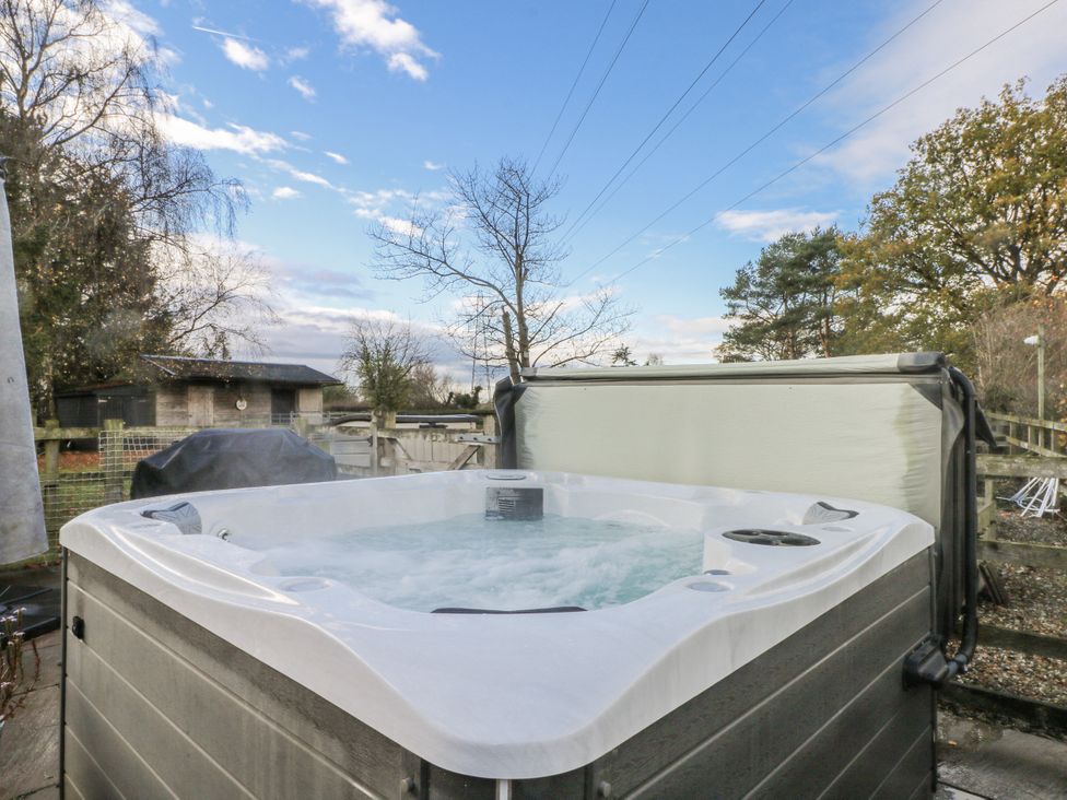 A hot tub with water jets in an outdoor area at Curlew Cottage Lower Peover Cheshire