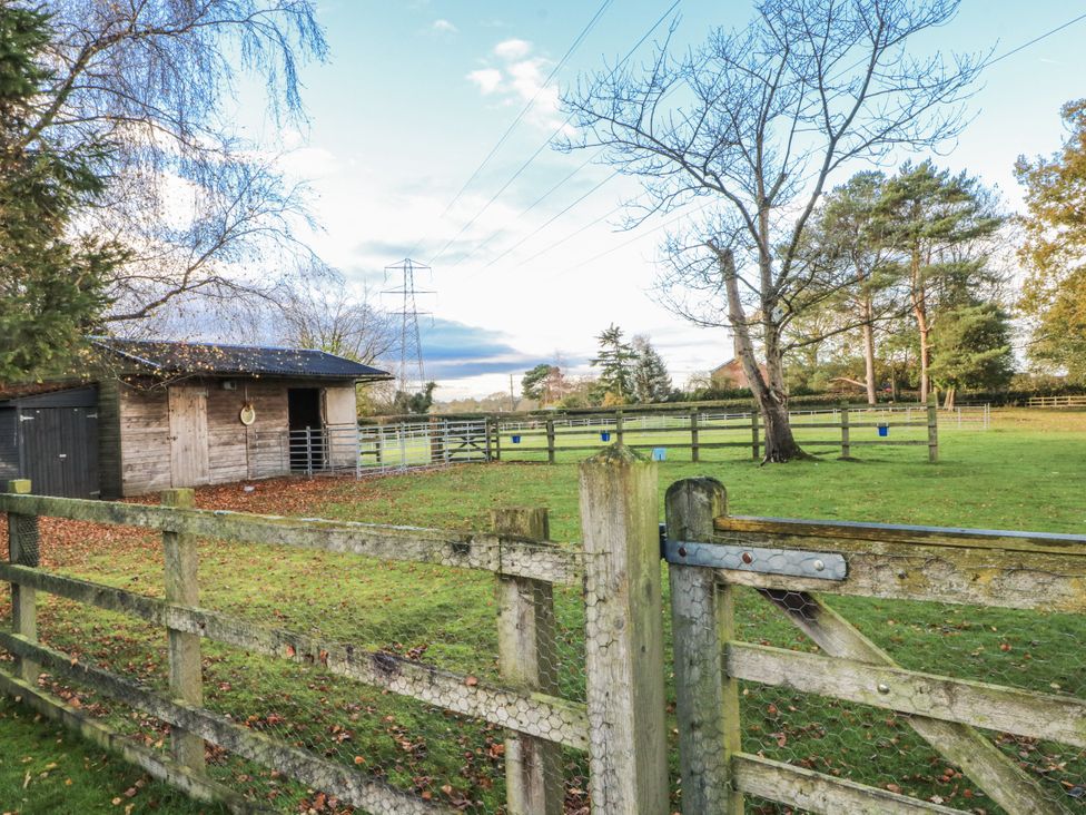An outdoor area with a wooden shed and a fence at Curlew Cottage Lower Peover Cheshire
