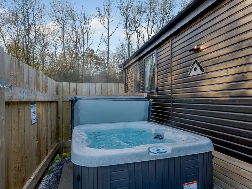 An outdoor area with a hot tub and wooden fence at Horncastle Spa in Louth