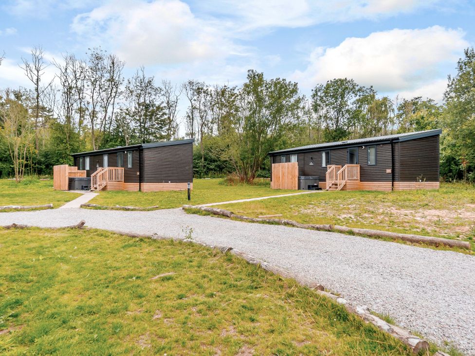 Two cabins with a path in a grassy area at Horncastle Spa Plus in Louth