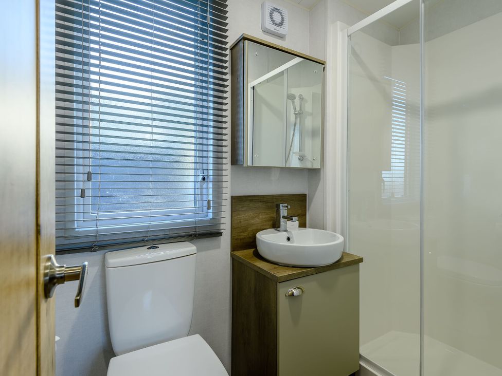 A bathroom with a toilet, sink, and shower at Horncastle Spa Plus in Louth