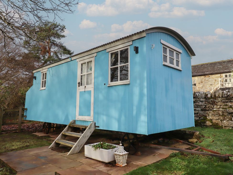 A blue shepherd's hut in a garden at Meadows in Hexham