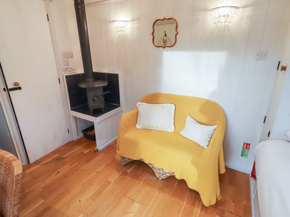 A snug with a sofa and wood stove at Meadows in Hexham