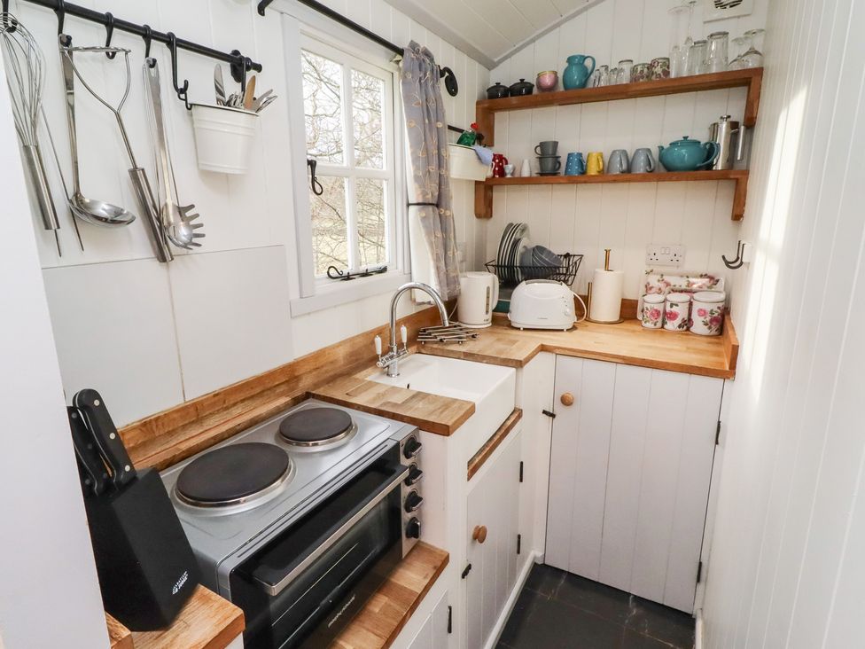 A kitchen with a sink, stove, and storage at Meadows in Hexham