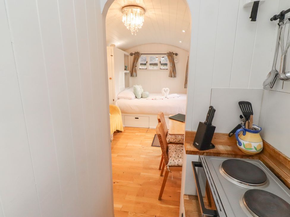 A kitchen with a table and chairs leading to a bedroom at Meadows in Hexham