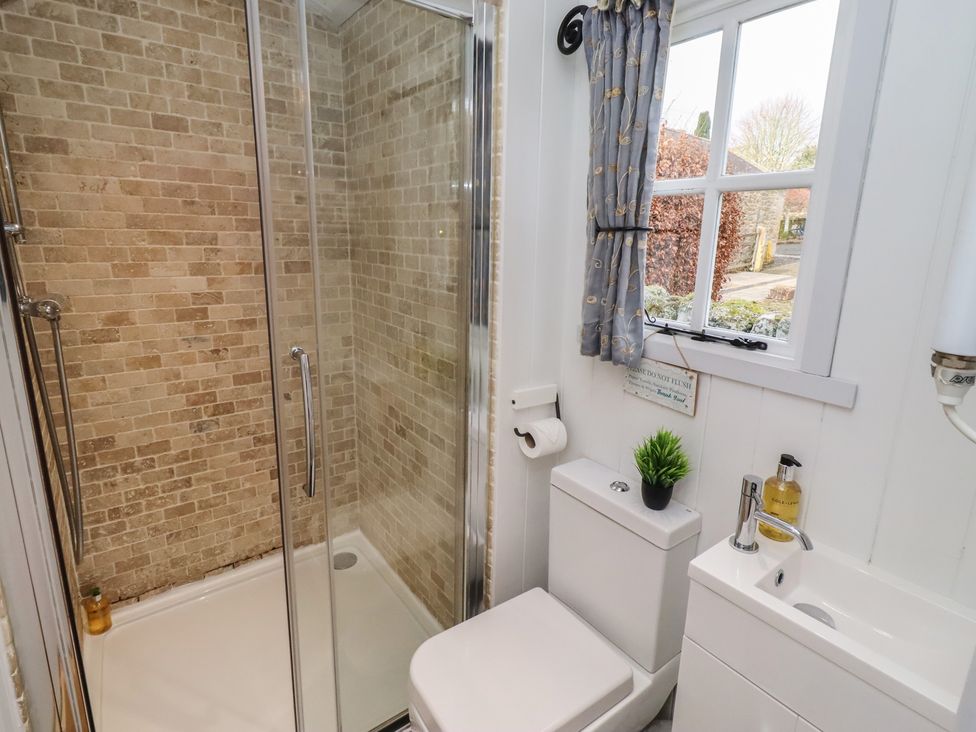 A bathroom with a shower, toilet, and sink at Meadows in Hexham
