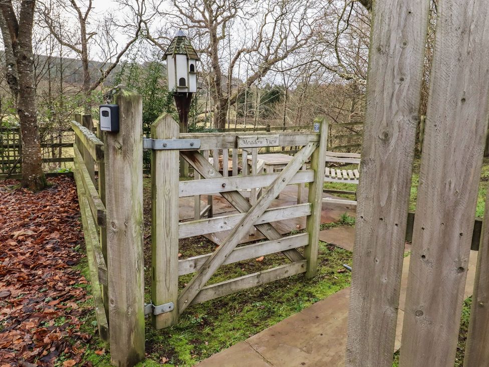 A gate and bench in a garden area at Meadows in Hexham