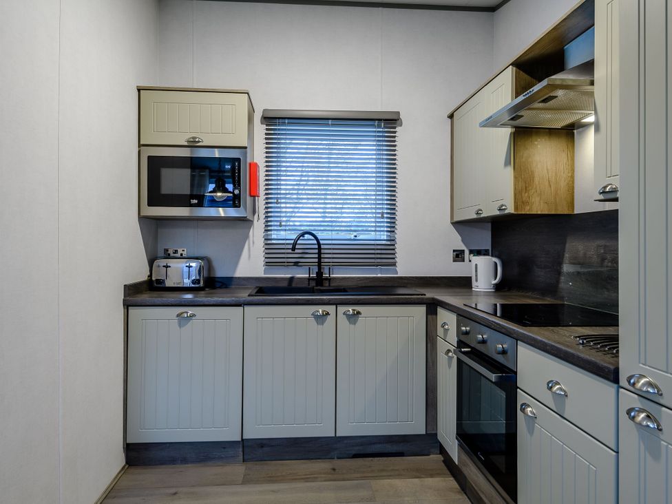 A kitchen with cabinets and appliances at The Kinder Spa (Pet) Louth