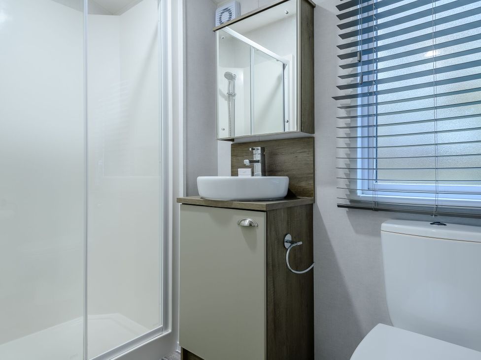 A bathroom with a shower, sink, and mirror at Alford Spa (Pet) in Louth