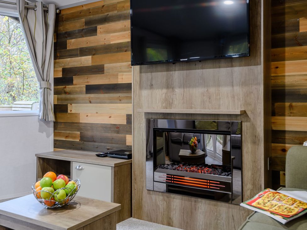 A living room with a television, fireplace, and fruit basket at Alford Spa (Pet) in Louth