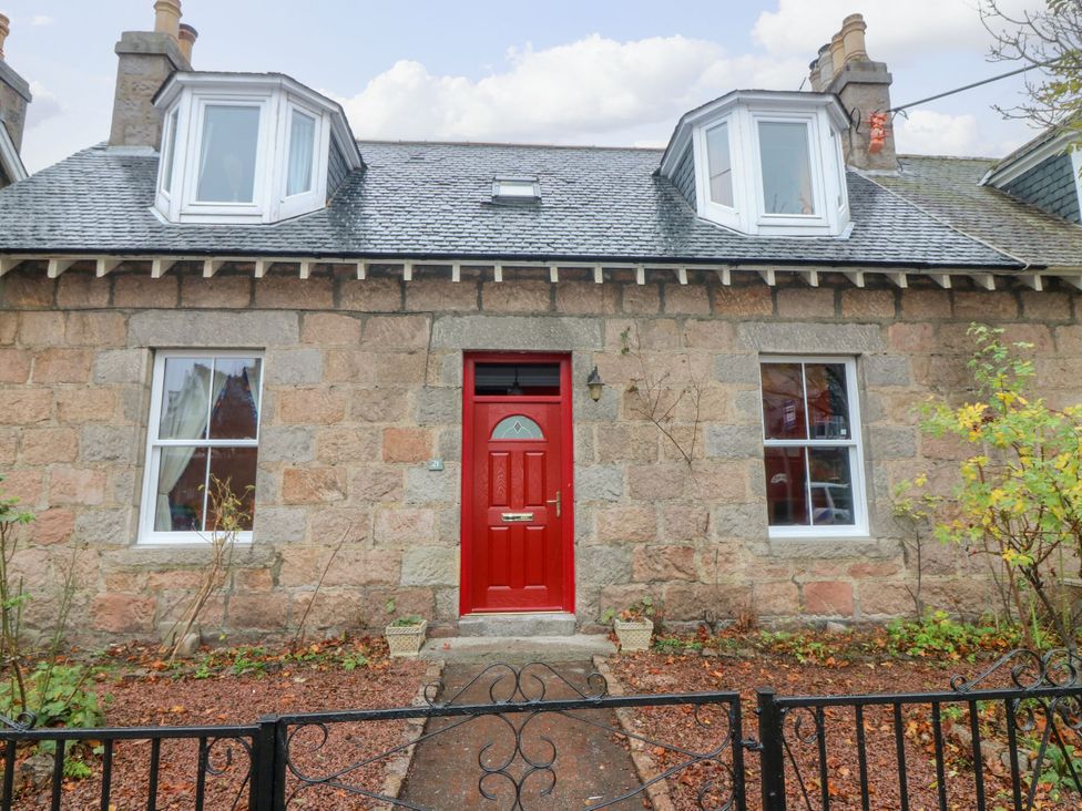 A house facade with a red door and windows at Lindean in Ballater