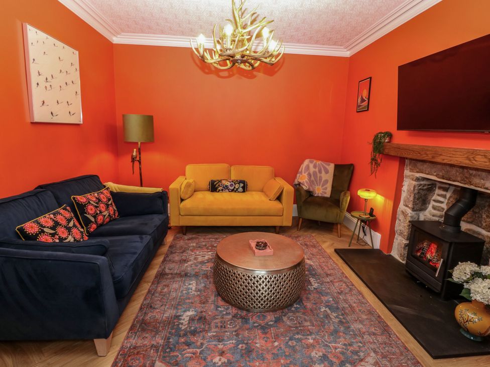 A living room with a yellow sofa and a blue sofa at Lindean in Ballater