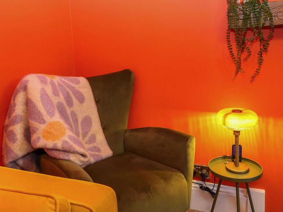 A living room with an armchair and a lamp at Lindean Ballater