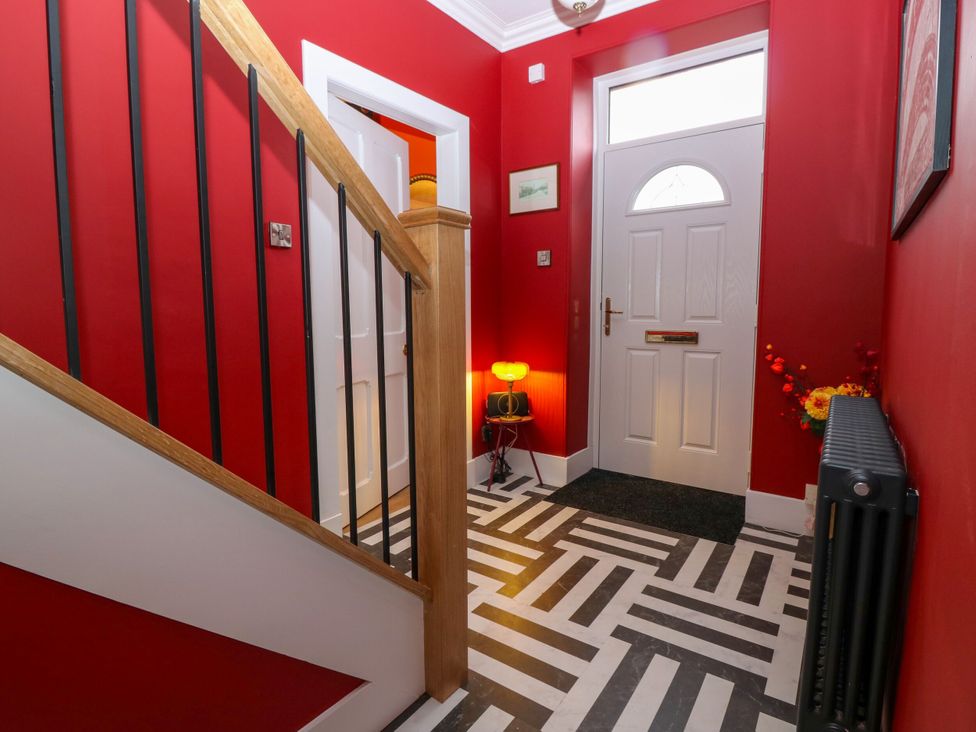 A hallway with a staircase and a front door at Lindean in Ballater