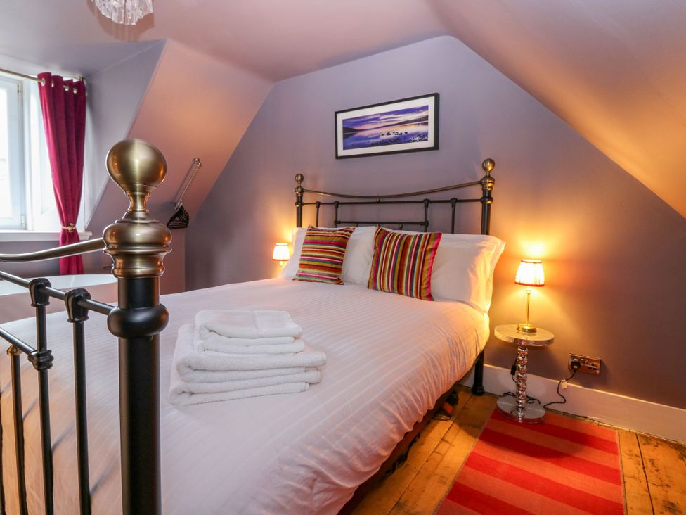 A bedroom with a bed and bedside lamp at Lindean in Ballater