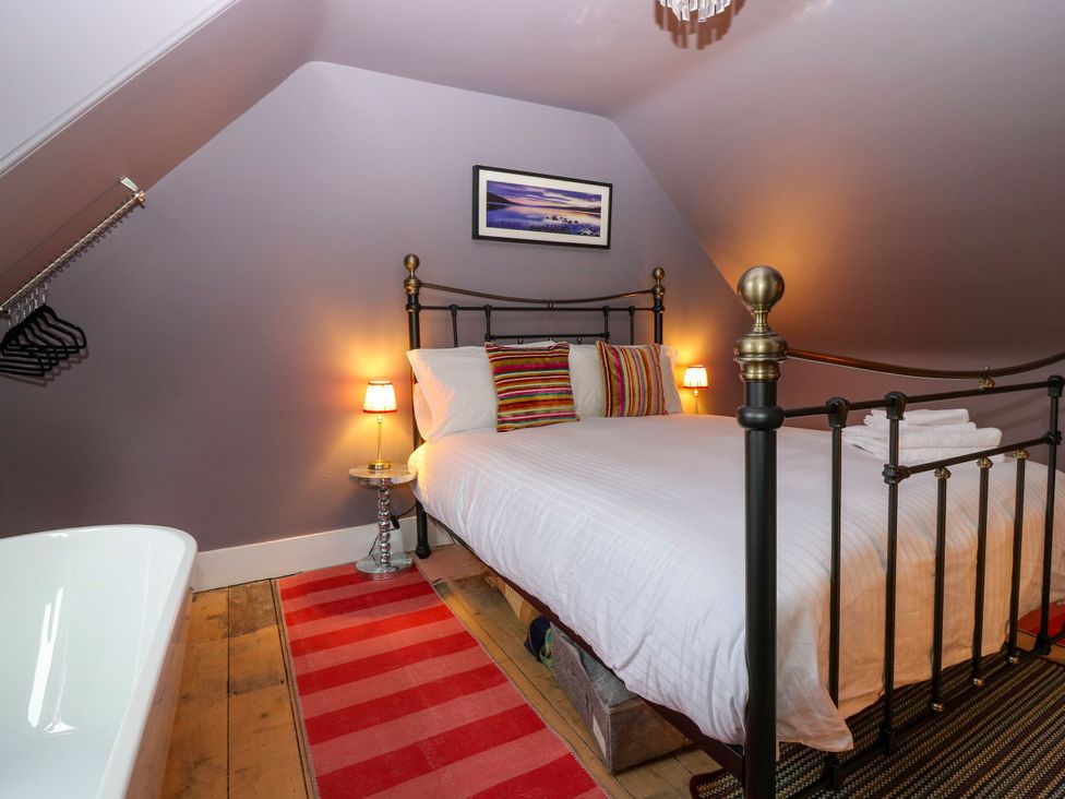 A bedroom with a bed and a bathtub at Lindean in Ballater