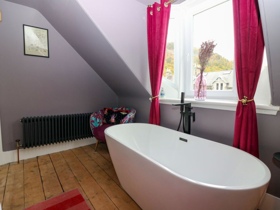 A bathroom with a freestanding bathtub and a radiator at Lindean in Ballater