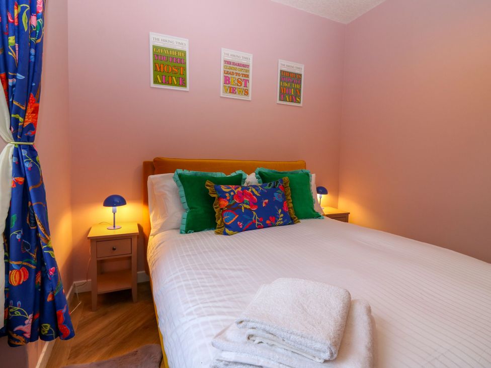 A bedroom with a bed and nightstands at Lindean in Ballater