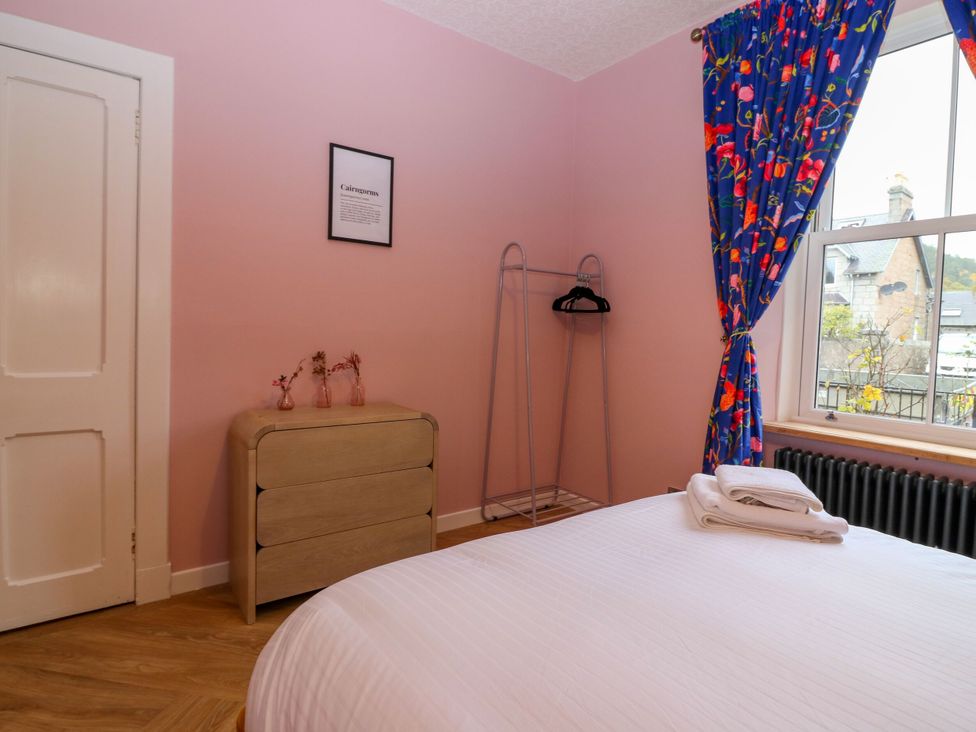 A bedroom with a window and a chest of drawers at Lindean in Ballater