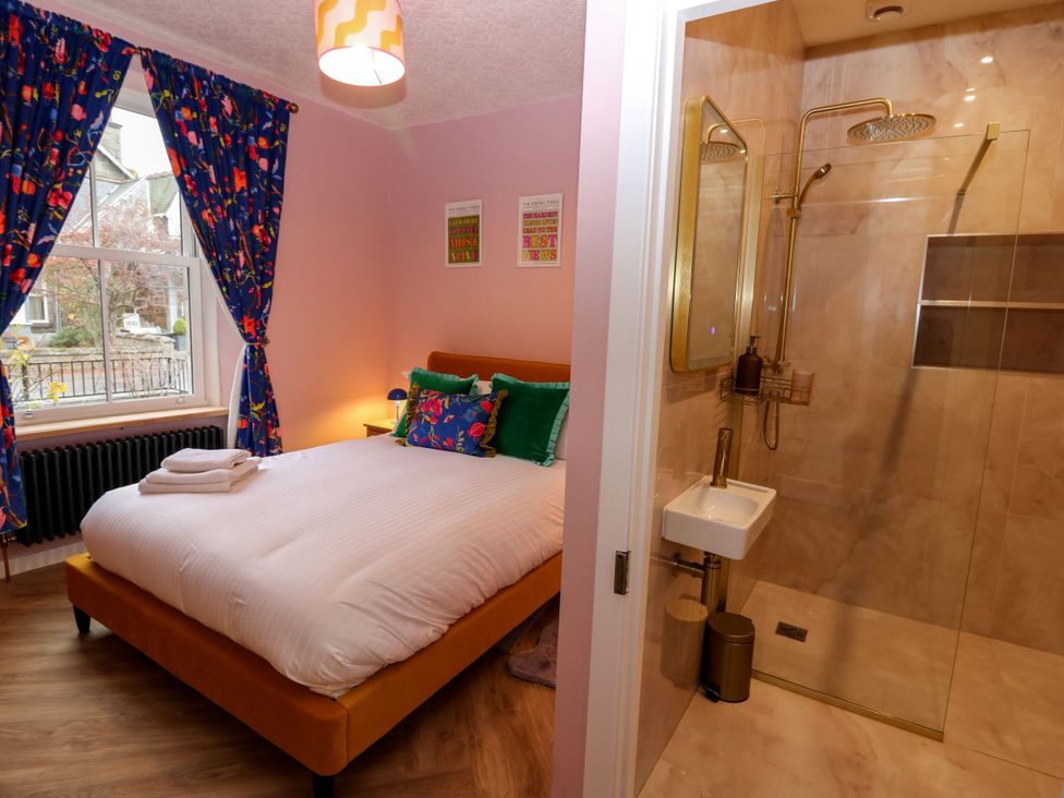 A bedroom with a bed, shower, and window at Lindean in Ballater