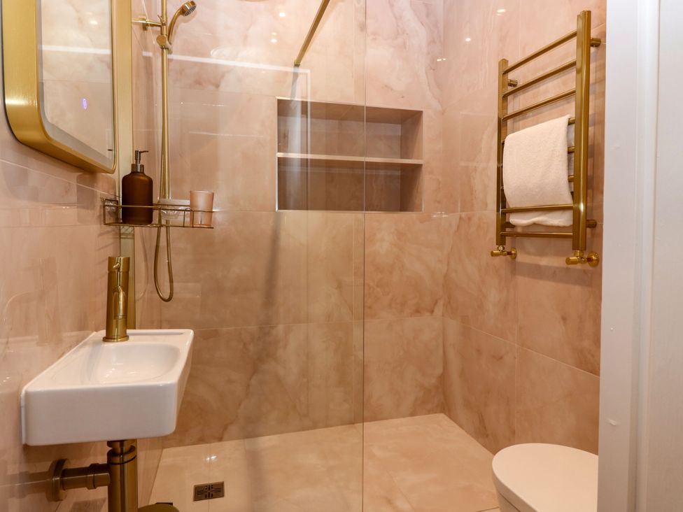 A bathroom featuring a shower, wash basin, towel rack, and toilet at Lindean Ballater