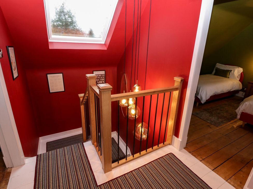 A staircase with lights and wall art in the hallway at Lindean Ballater