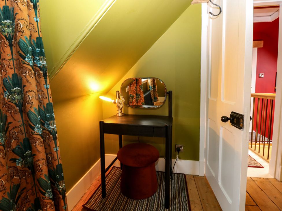 A dressing area with a vanity table and stool at Lindean in Ballater