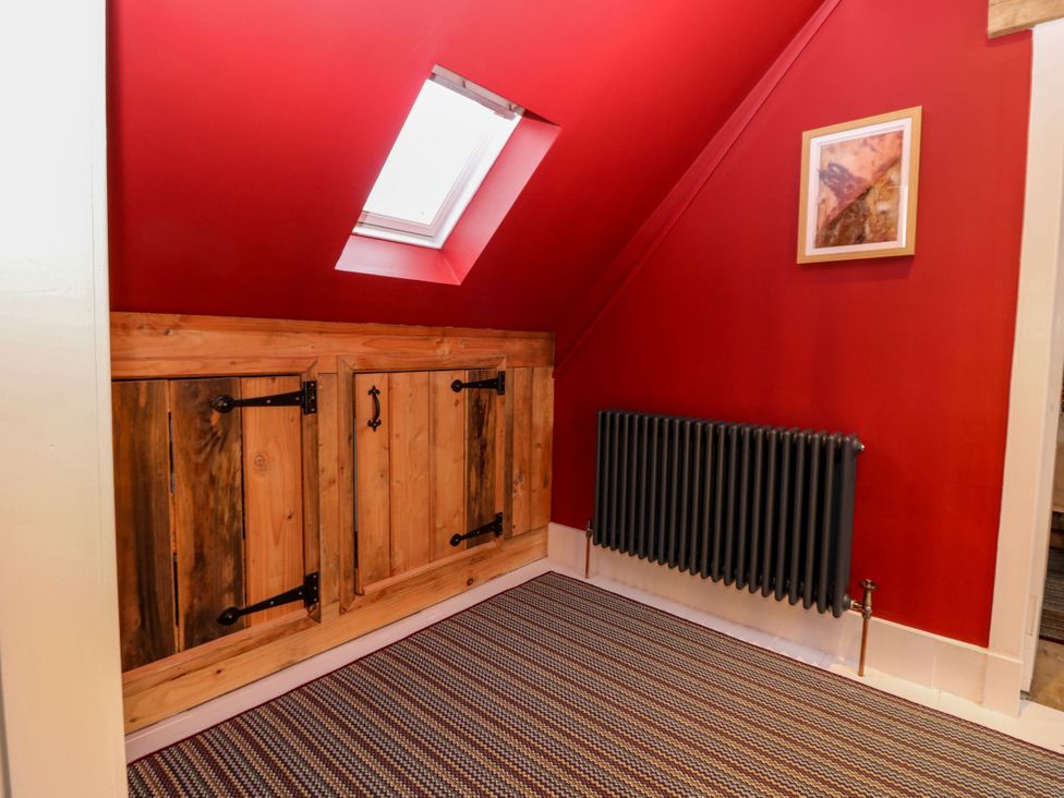 A landing area with a wooden cupboard and radiator at Lindean in Ballater