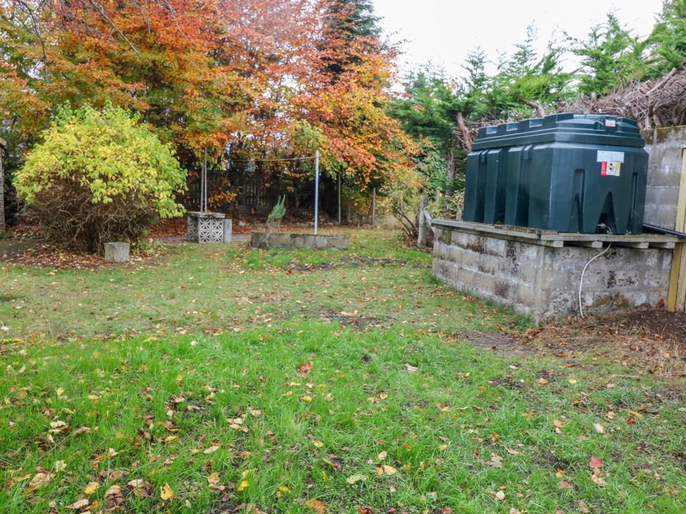 A garden with a water tank and bushes at Lindean in Ballater