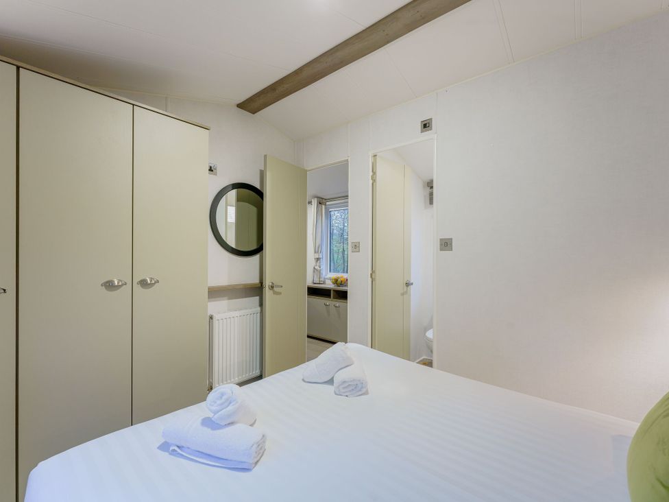 A bedroom with a bed and wardrobe at Horncastle Spa Plus (Pet) in Louth