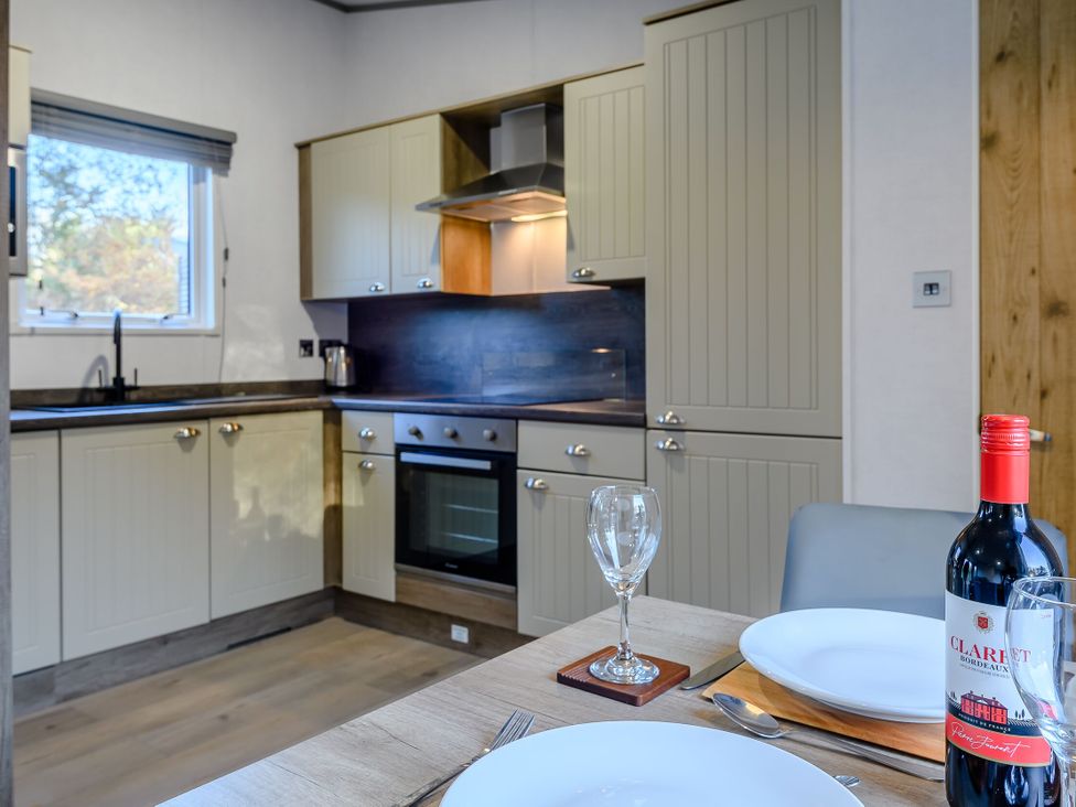 A kitchen with cabinets and a dining table at Horncastle Plus (Pet) Louth