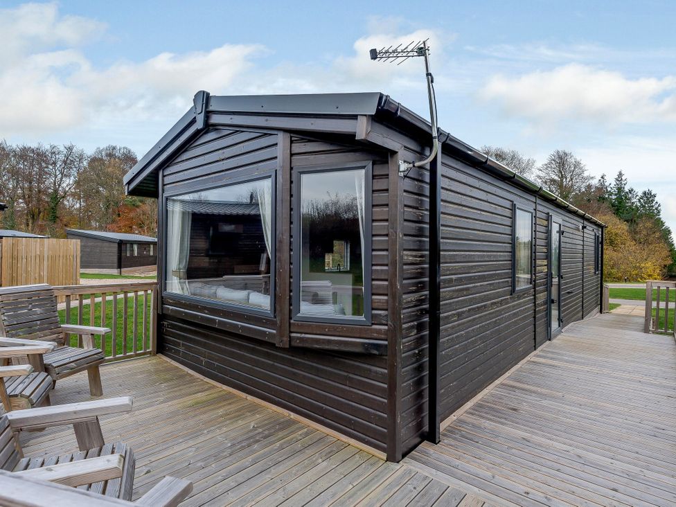 A cabin exterior with a deck and seating at Alford WF in Louth