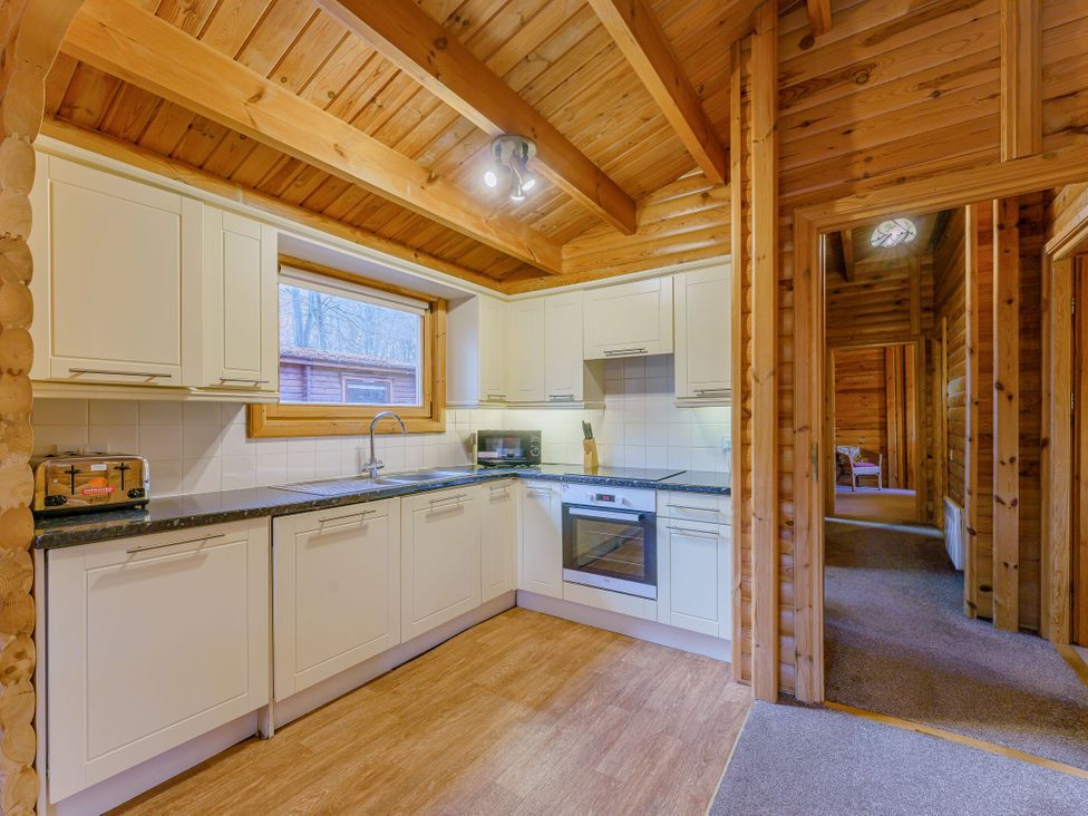 A kitchen with cabinets and appliances at Cedar Lodge in Louth