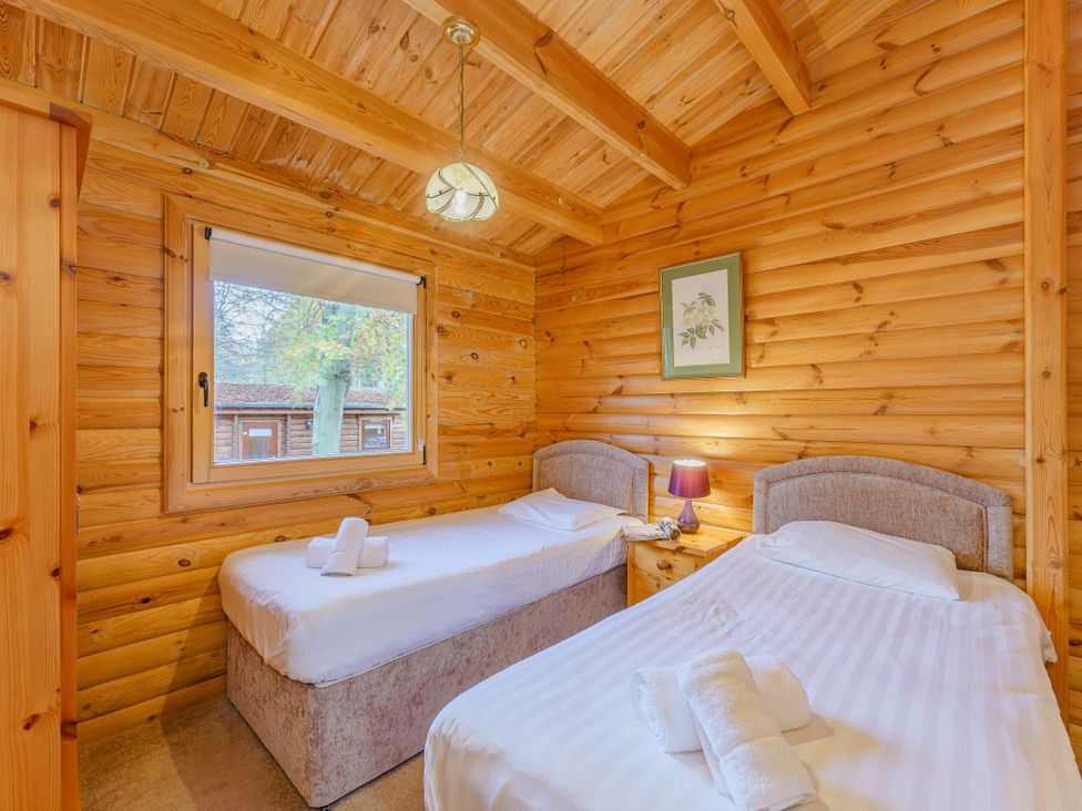 A bedroom with two beds and a window at Cedar Lodge in Louth