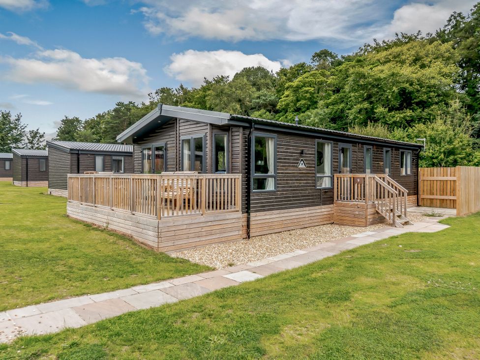 A wooden cabin with a deck and steps in an outdoor area at Elsham Lodge in Louth