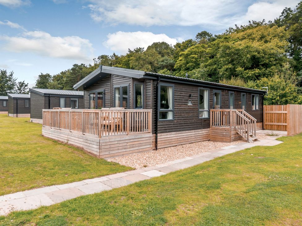 A log cabin with a deck and pathway at Elsham Lodge in Louth