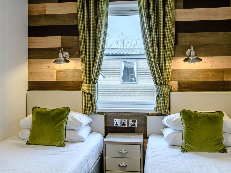 A bedroom with two beds and a window at Elsham Lodge in Louth