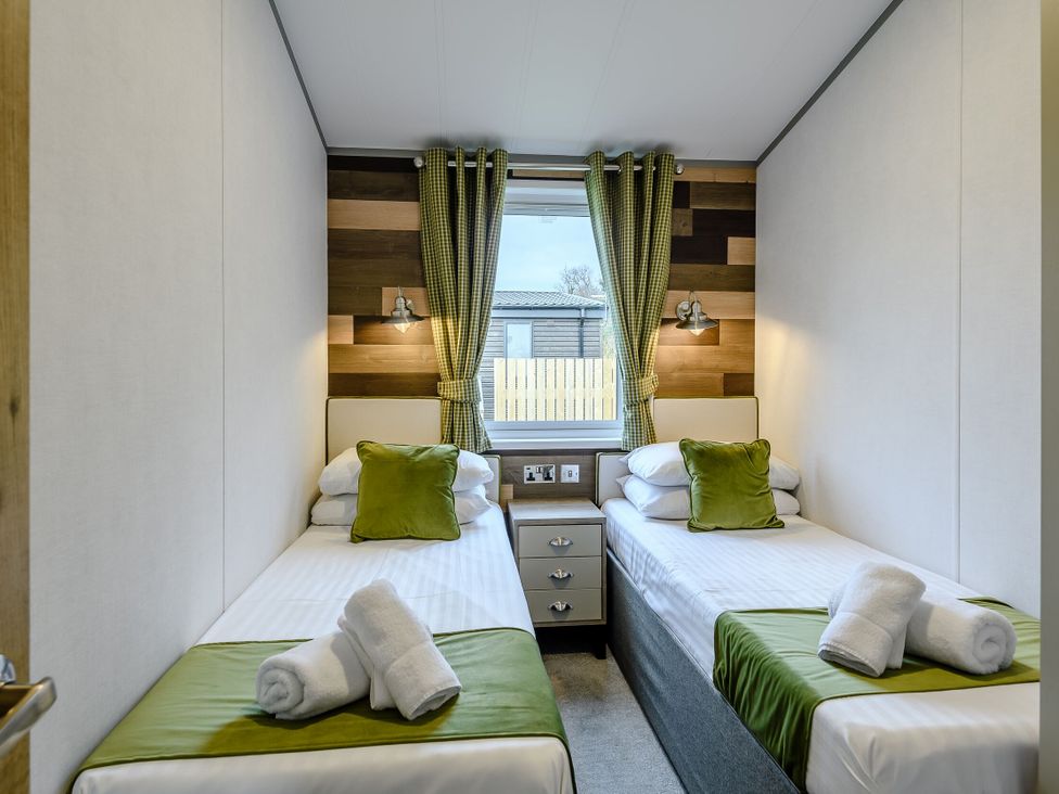 A bedroom with two beds and a window at Elsham Lodge in Louth