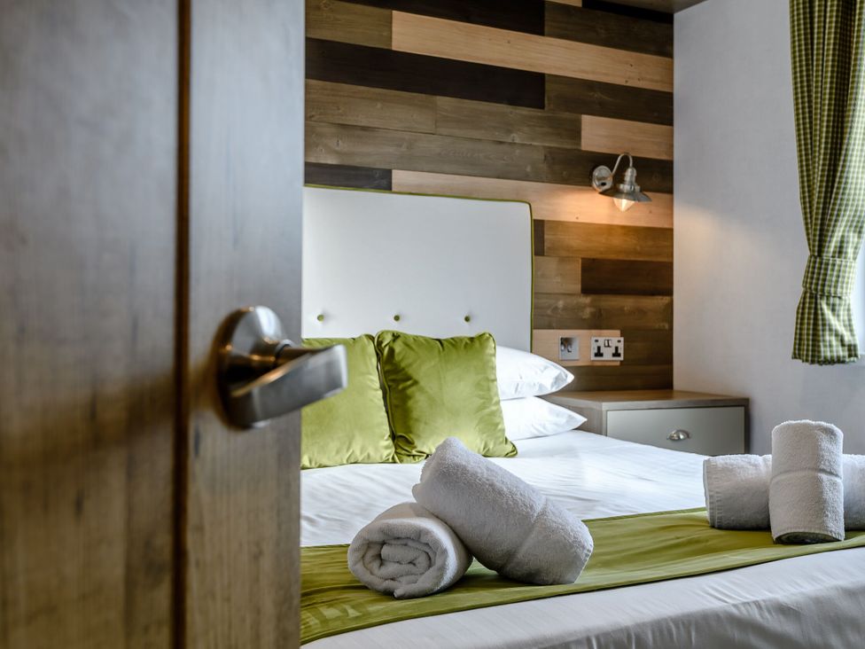 A bedroom with a bed and towels arranged at Elsham Lodge in Louth