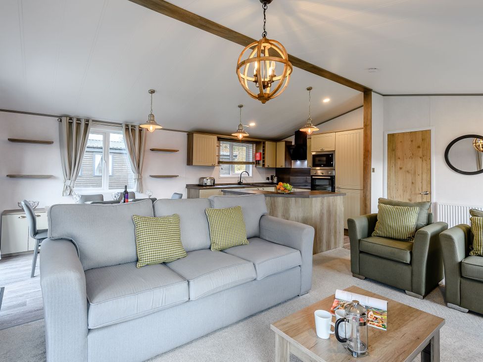 A living room with a sofa and kitchen island at Elsham Lodge in Louth