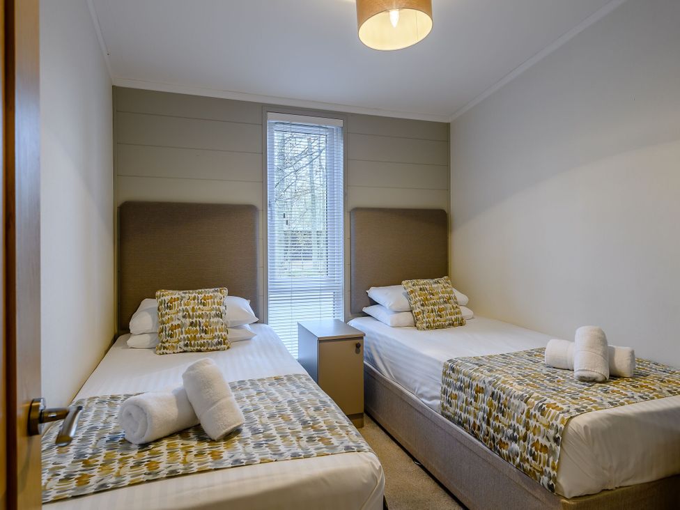A bedroom with twin beds and a nightstand at Stamford Spa in Louth