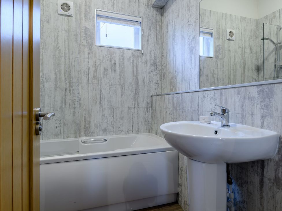 A bathroom with a bathtub and sink at Stamford Spa in Louth