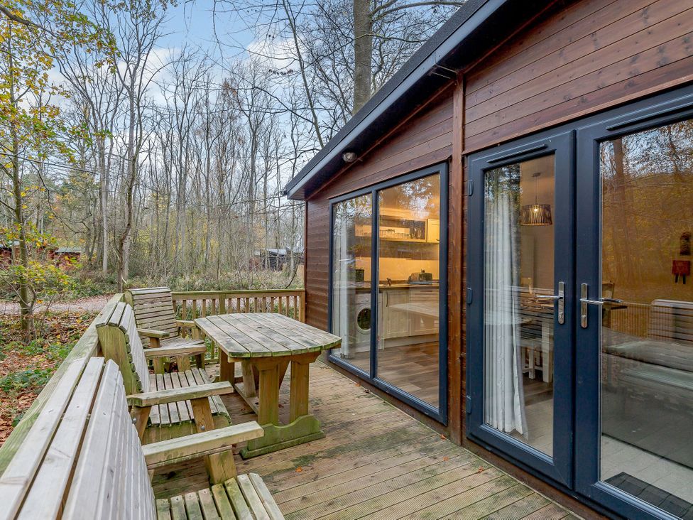 An outdoor area with a wooden table and chairs at Stamford Spa in Louth
