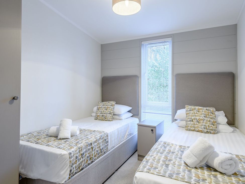 A bedroom with two single beds and a window at Stamford Spa (Pet) in Louth
