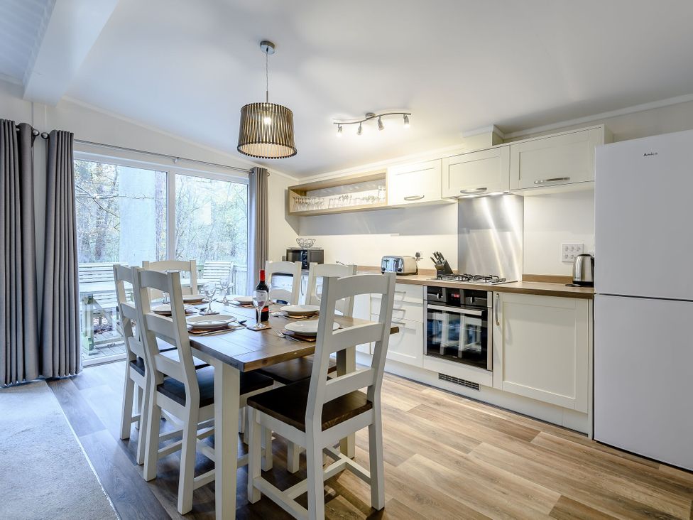 A dining room with a table and kitchen appliances at Stamford Spa (Pet) in Louth