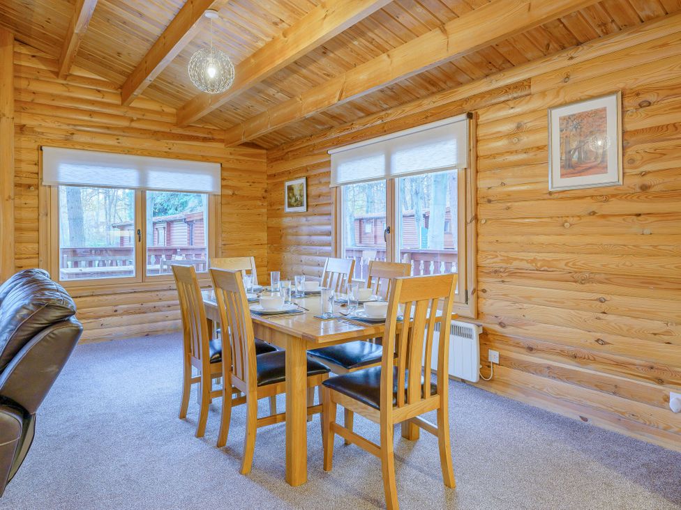 A dining room with a table and chairs at Cedar Lodge (Pet) in Louth