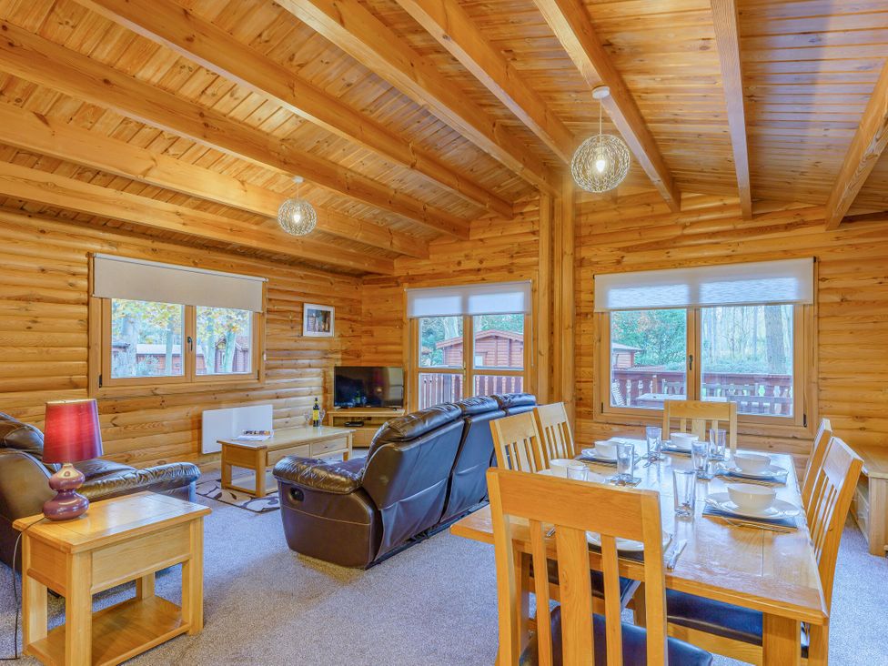 A living room with a sofa and dining table at Cedar Lodge (Pet) Louth